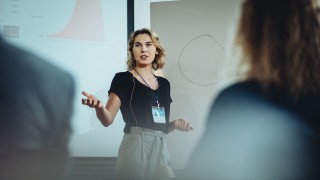 Woman presenting her idea to colleagues in meeting. Businesswoman public speaking in a conference meeting.